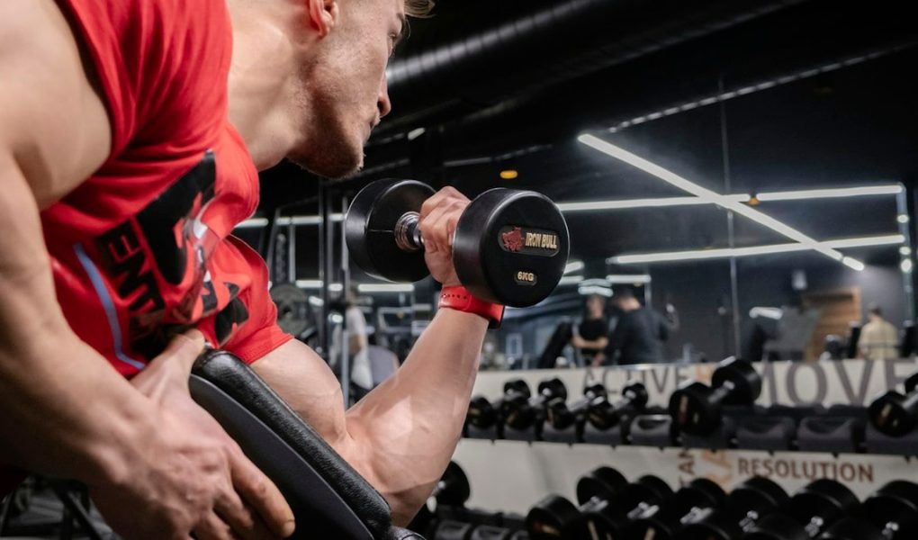 a man lifting a dumbbell in a gym