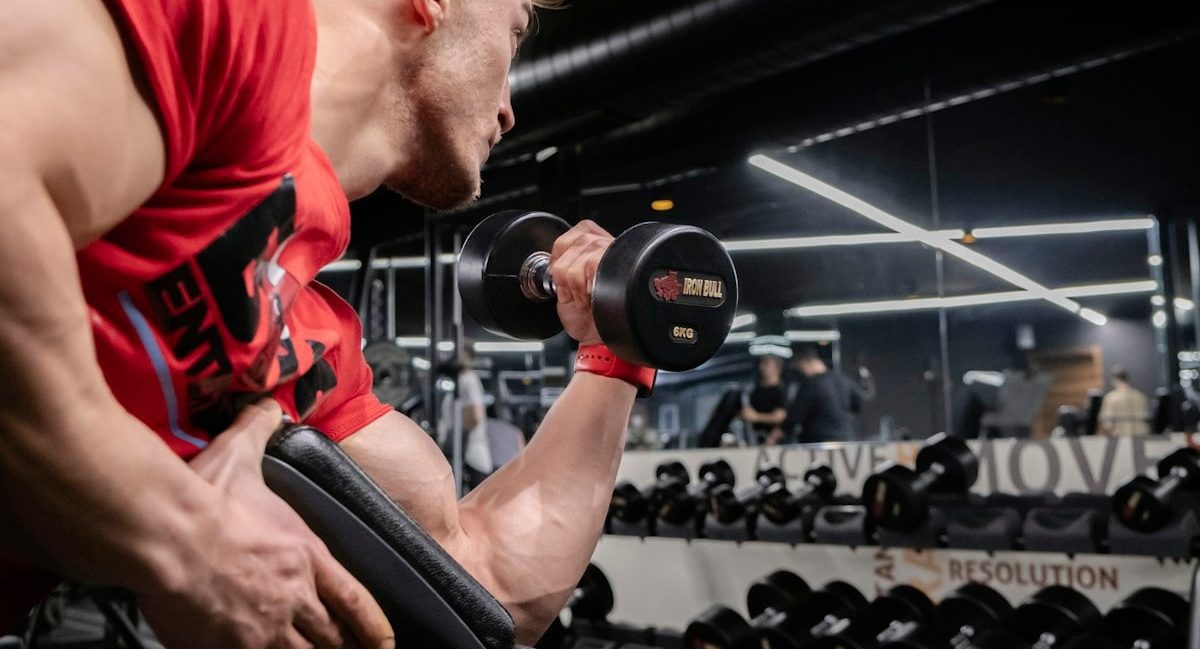 a man lifting a dumbbell in a gym