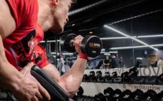 a man lifting a dumbbell in a gym